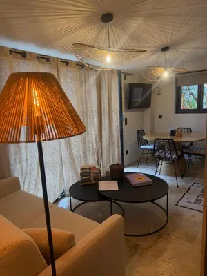 a living room with a couch and a table with a lamp at Charmant appartement T2 cosy avec piscine in Mollégès