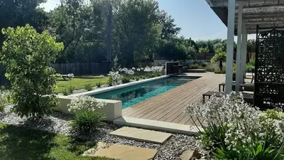 a backyard with a swimming pool and a wooden deck at Villa 5 étoiles, 6 personnes in LʼIsle-sur-la-Sorgue