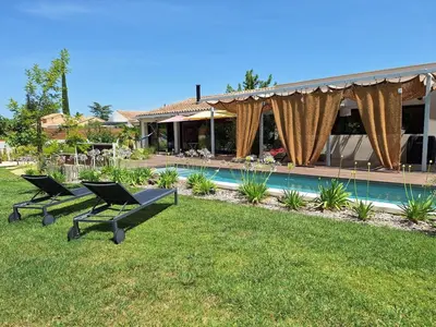a house with two chairs and a swimming pool at Villa 5 étoiles, 6 personnes in LʼIsle-sur-la-Sorgue