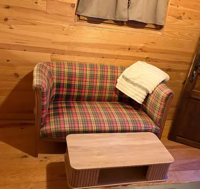 a living room with a plaid chair and a table at Chicken roulotte des 3 cèdres in Cavaillon