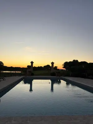 a pool with the sunset in the background at Appartement domaine de Pont Royal in Mallemort
