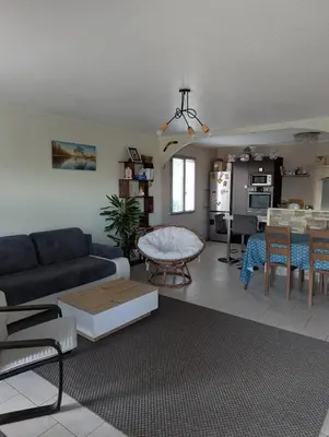 a living room with a couch and a table at Maison 3 pièces avec jardin et terrasse in La Fare-les-Oliviers