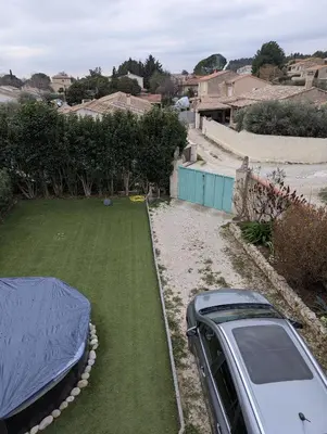 a car parked in a yard with a lawn at Maison 3 pièces avec jardin et terrasse in La Fare-les-Oliviers