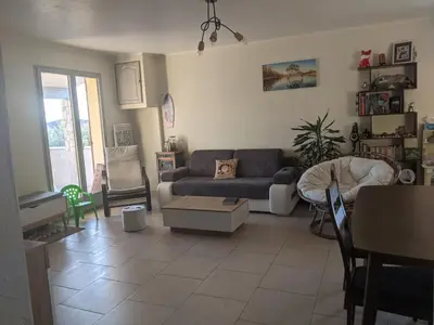 a living room with a couch and a table at Maison 3 pièces avec jardin et terrasse in La Fare-les-Oliviers