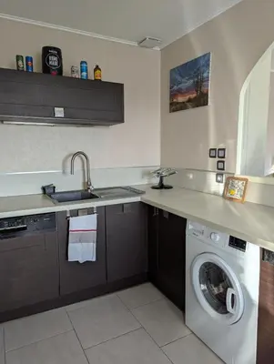 a kitchen with a sink and a washing machine at Maison 3 pièces avec jardin et terrasse in La Fare-les-Oliviers