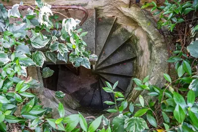 an old grate in a garden with green plants at Rock House Pool & Authentic 17th-Century Home in Goult
