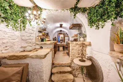 a room with a stone wall with a table and a counter at Rock House Pool & Authentic 17th-Century Home in Goult