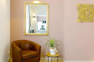 a chair and a mirror in a room at Appartement 1 chambre, 2 lits, vue Cathédrale in Aix-en-Provence