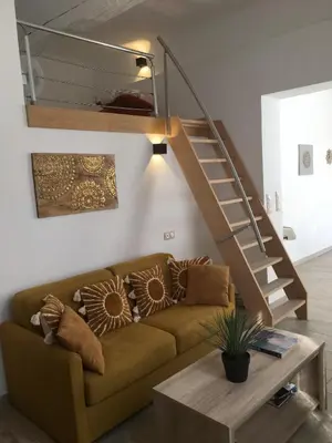 a living room with a couch and a staircase at Appartement 1 chambre, 2 lits, vue Cathédrale in Aix-en-Provence