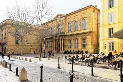a courtyard with tables and chairs in front of a building at Appartement 1 chambre, 2 lits, vue Cathédrale in Aix-en-Provence