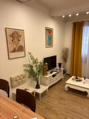 a living room with a television and a table at Appartement Turandot, 1 chambre, près du Cours Mirabeau in Aix-en-Provence