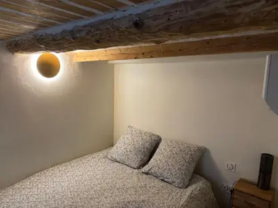 a bedroom with a bed with two pillows on it at Appartement Lotus Rouge, 2 chambres, proche Mairie in Aix-en-Provence