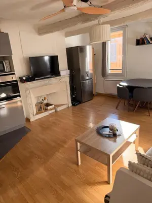 a living room with a coffee table and a kitchen at T2 spacieux en hyper centre pour 1 à 5 personnes in Aix-en-Provence