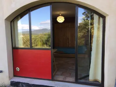 a red door with a view of a bedroom at Belle villa avec piscine, belle vue, calme absolu in Apt