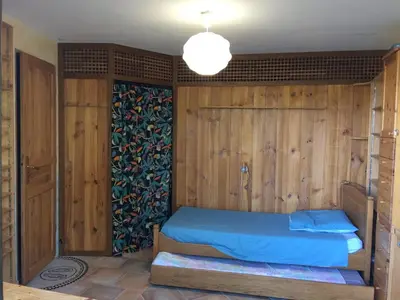 a bedroom with a bed with a wooden wall at Belle villa avec piscine, belle vue, calme absolu in Apt