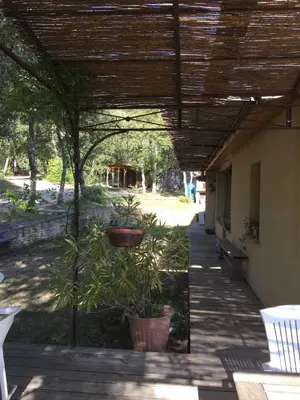 a patio with potted plants under a wooden roof at Belle villa avec piscine, belle vue, calme absolu in Apt