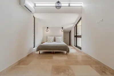 a bedroom with a bed in a white room at Magnifique villa au coeur de la campagne de Gordes in Gordes