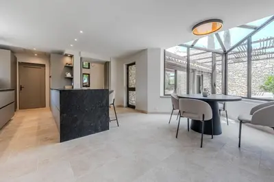 a kitchen and living room with a table and chairs at Magnifique villa au coeur de la campagne de Gordes in Gordes