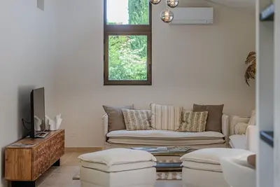 a living room with a couch and a tv at Magnifique villa au coeur de la campagne de Gordes in Gordes