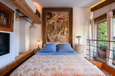 a bedroom with a bed with a painting on the wall at Romantic Provence Pool & Mill View in Goult