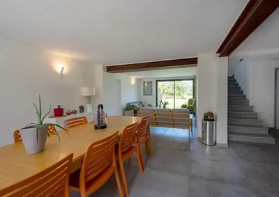 a dining room with a table and chairs and a staircase at mas de la bergerie in Cavaillon