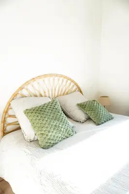 a bed with green and white pillows on it at L Appartement 1 Chambre - Gîte la Bergerie du Ventoux in Mormoiron