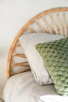 a green and white pillow sitting on a bed at L Appartement 1 Chambre - Gîte la Bergerie du Ventoux in Mormoiron