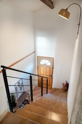 a staircase in a house with a wooden door at La Maison Duplex 3 Chambres - Gîte La Bergerie du Ventoux in Mormoiron