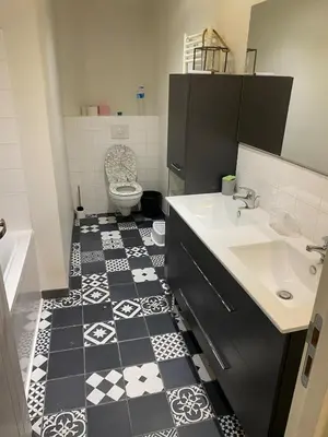 a bathroom with a black and white tile floor at The Provençal orchid in Malemort-du-Comtat