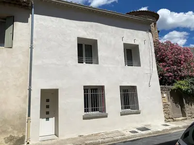a white building with three windows and a flowering bush at The Provençal orchid in Malemort-du-Comtat