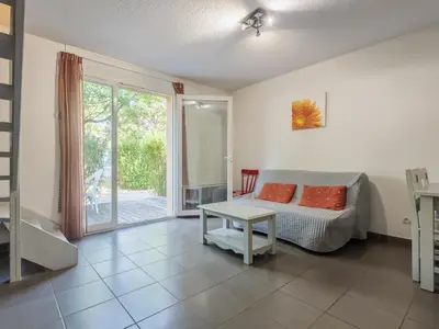 a living room with a bed and a table at D du Ventoux D N55 3P6 in Aubignan