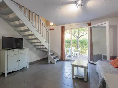a living room with a staircase and a television at D du Ventoux D N55 3P6 in Aubignan