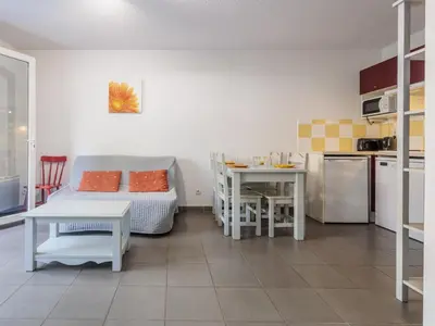 a kitchen and a living room with a couch and a table at D du Ventoux D N55 3P6 in Aubignan