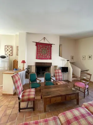 a living room with chairs and a table and a fireplace at Pierre Jacques' House in Caromb