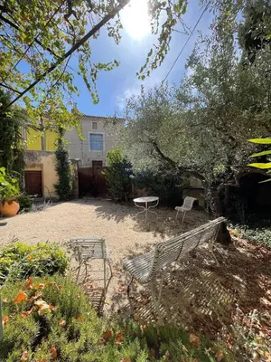 a garden with two benches and a table and a building at Pierre Jacques' House in Caromb