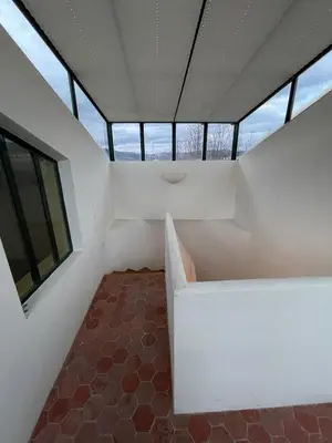 a small room with white walls and windows at Pierre Jacques' House in Caromb