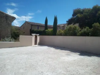 a fence in front of a house with trees at Mas De Hameau in Oppède