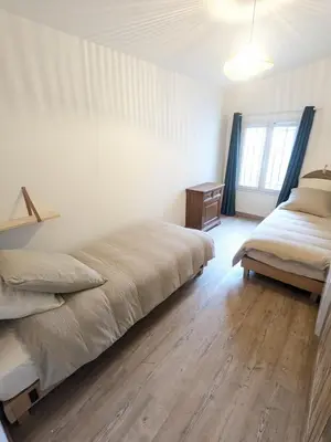 a bedroom with two beds and a wooden floor at Le gîte du domaine de Sinaca Villa in Sénas