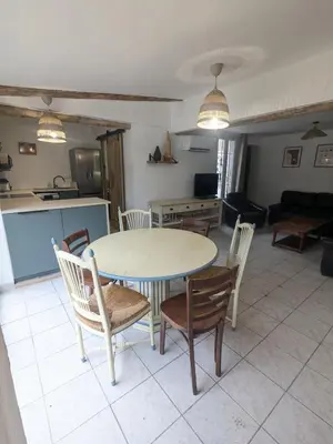 a kitchen and living room with a table and chairs at Le gîte du domaine de Sinaca Villa in Sénas