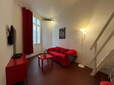 a living room with a red couch and a red blanket at Joli appartement atypique dans le centre d'Aix in Aix-en-Provence