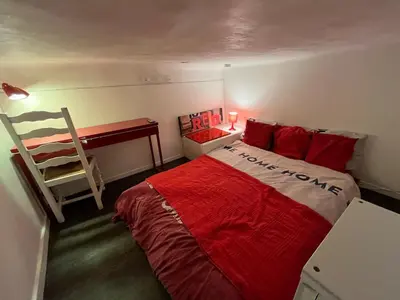 a bedroom with a bed with red pillows and a ladder at Joli appartement atypique dans le centre d'Aix in Aix-en-Provence