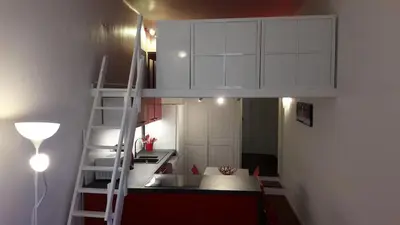 a small kitchen with a loft bed in a room at Joli appartement atypique dans le centre d'Aix in Aix-en-Provence