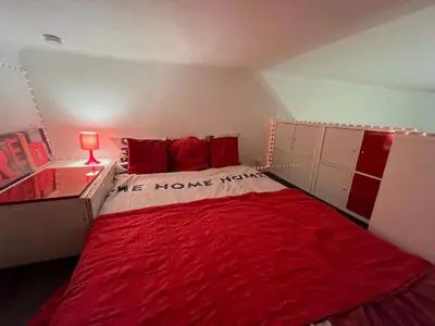 a bedroom with a red bed with a red blanket at Joli appartement atypique dans le centre d'Aix in Aix-en-Provence