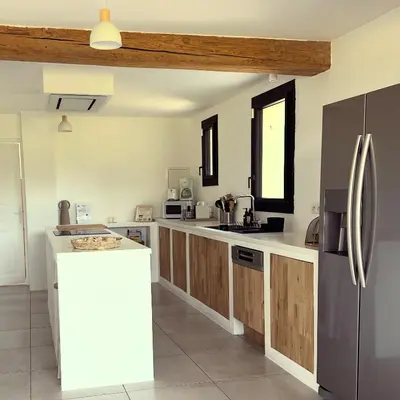 a kitchen with wooden cabinets and stainless steel appliances at Superbe mas provençal avec piscine dans le Luberon in Lagnes