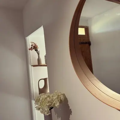 a mirror on a wall with a vase of flowers at Superbe mas provençal avec piscine dans le Luberon in Lagnes