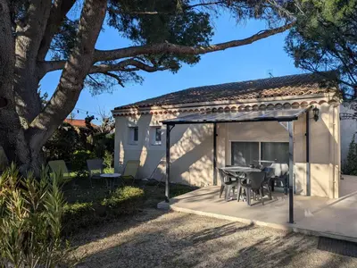 a kitchen and dining room with a table and chairs at À l'ombre du pin in Entraigues-sur-la-Sorgue