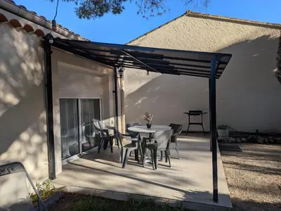 a patio with a table and a tree at À l'ombre du pin in Entraigues-sur-la-Sorgue