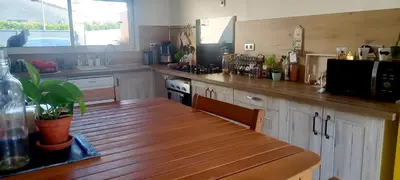 a kitchen with a wooden table and a counter top at Le Colibri Très belle maison près d'Avignon in Carpentras