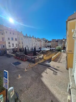 a street with tables and umbrellas in a city at Grand studio dans le centre historique in Aix-en-Provence