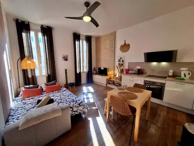 a living room with a couch and a table at Grand studio dans le centre historique in Aix-en-Provence